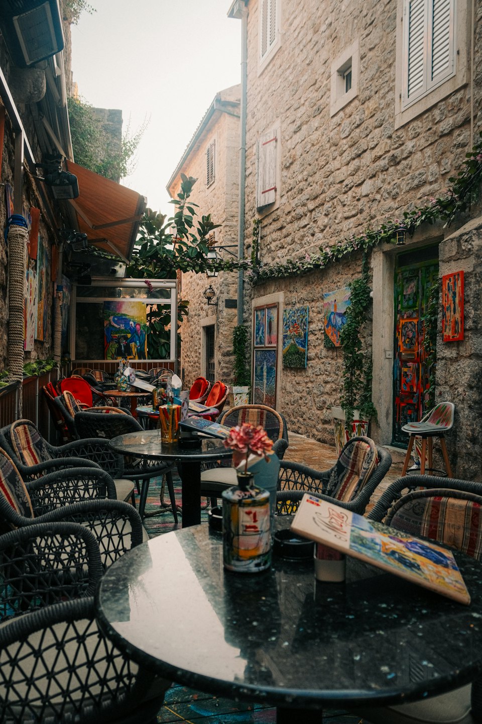 Outdoor cafe tables and chairs in a charming alleyway.